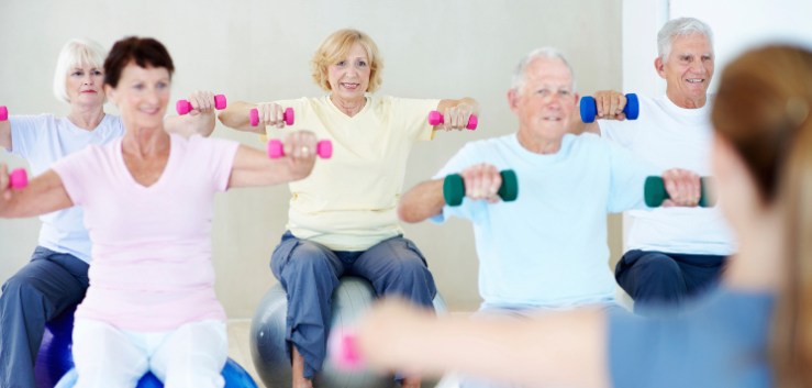 A group of elderly people lifting weights together in a fitness class
